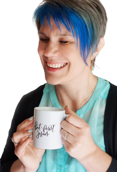 woman smiling while holding coffee mug