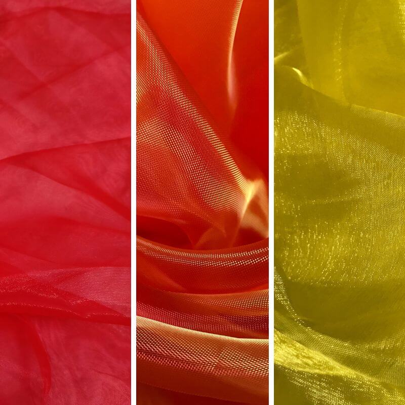 Side-by-side close-up of red, orange, and yellow sheer fabrics, showcasing their translucent texture and shimmer for worship flag making.