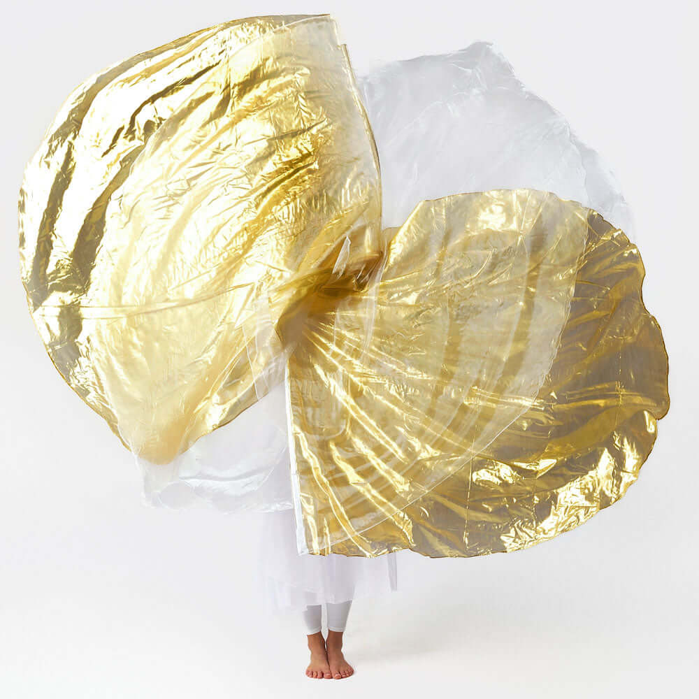 White and gold Christian worship flags in motion, lifted by a barefoot praise dancer dressed in white, captured mid-flow during a liturgical dance performance.