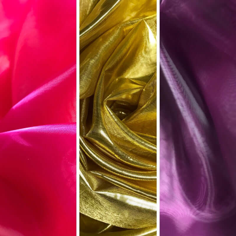 Close-up of vibrant worship flag fabrics in scarlet red, radiant gold, and royal purple, each folded and draped to showcase shimmer and texture.