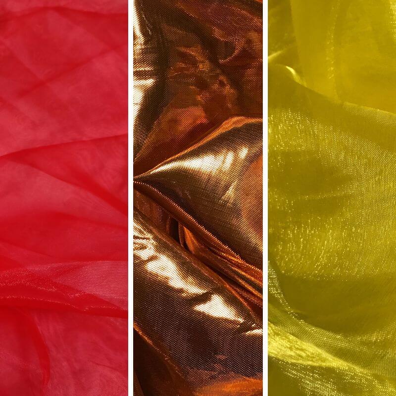 Trio of fabric swatches in red, copper, and yellow, showcasing translucent and metallic textures used for worship flags and praise dance.