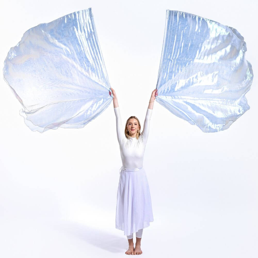 Worship dancer stretches with double-layer Holy & Blameless iridescent flags flowing wide. A radiant expression of praise representing the Holy Spirit and overcoming faith.