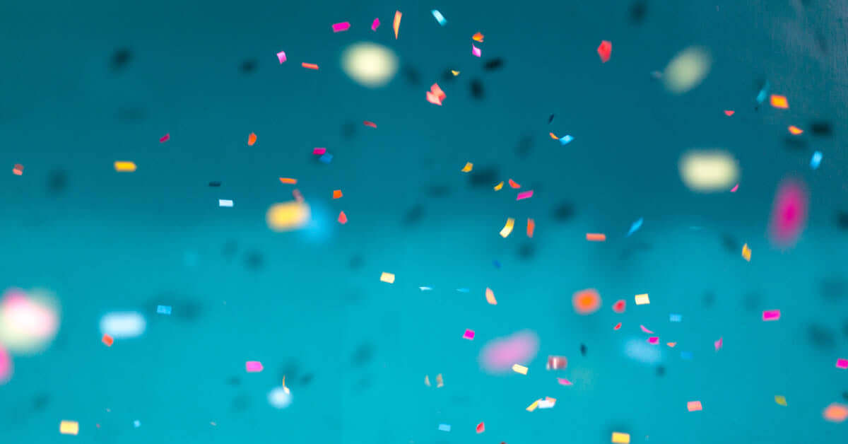 Slightly out of focus background photo of colorful confetti on a blue background