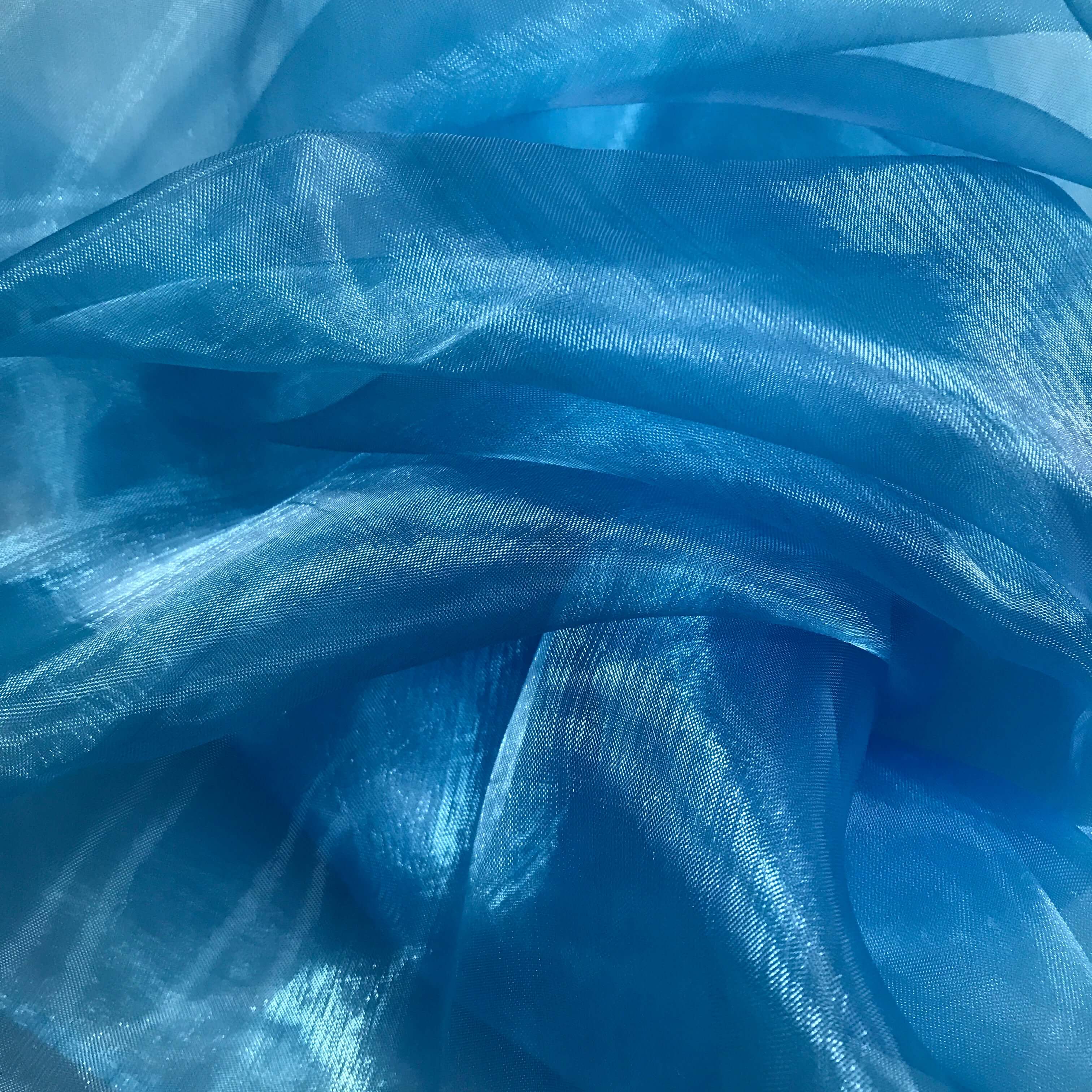Shimmering blue sheer fabric with soft folds and iridescent highlights, perfect for worship flags symbolizing living water, revelation, and heaven’s atmosphere.