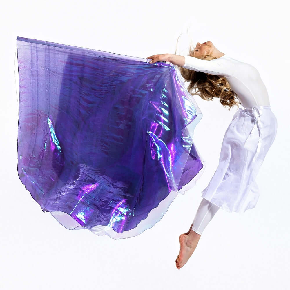 Prophetic dancer leaps with Casting Crowns double-layer worship flags in lilac and purple. Flags symbolize royal worship and surrender before the throne.