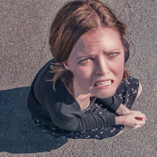 Young woman sitting on pavement, looking upward with anguish — capturing the cry of the heart when feeling overwhelmed, misunderstood, or spiritually dry. Reflects the starting place for breakthrough and healing through worship.
