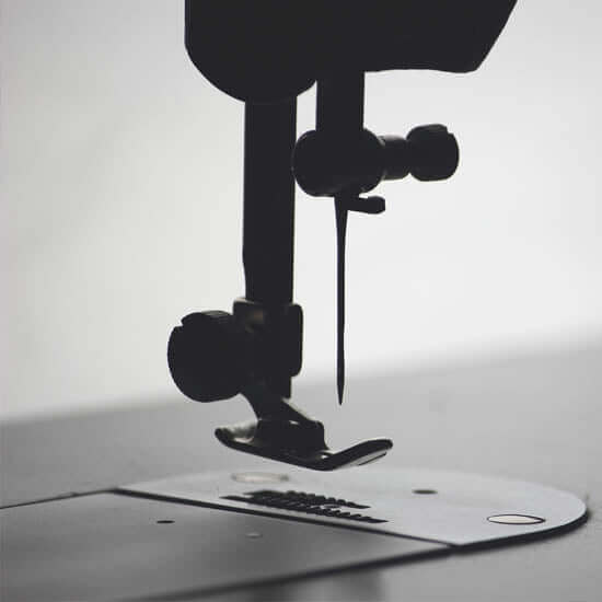 Close-up silhouette of a sewing machine needle — representing the craftsmanship, care, and prayerful precision behind each worship flag made at Catch the Fire Worship Flags.