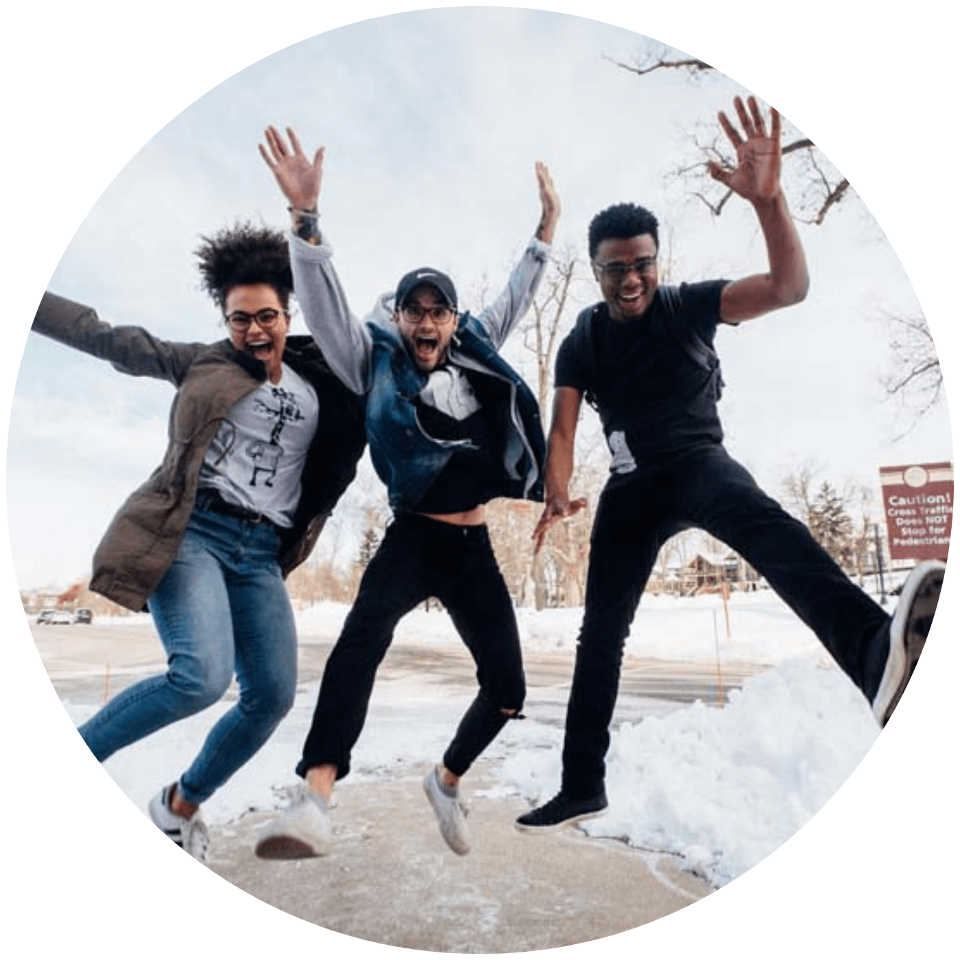 Three young adults jumping joyfully in a snowy urban setting, celebrating community and friendship
