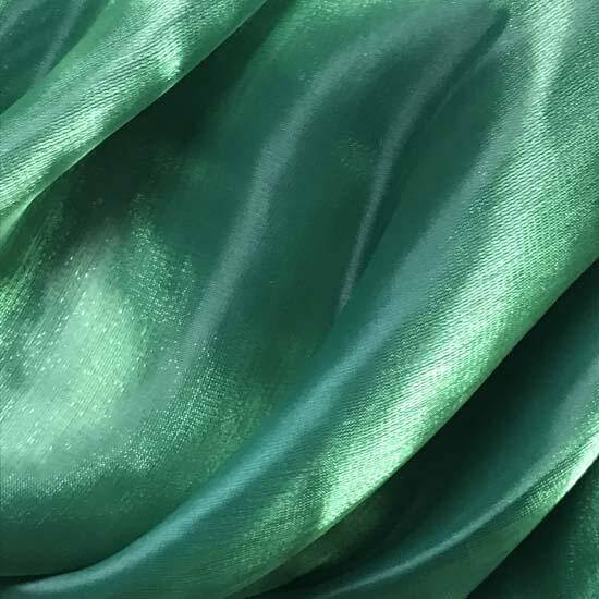 Close-up of iridescent green shimmer fabric with soft folds and light reflection, used in worship flags for expressive praise and movement.