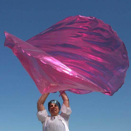 Worshipper lifting radiant scarlet pink worship flag under a clear blue sky, symbolizing healing, joy, and the extravagant love of Jesus through prophetic movement.