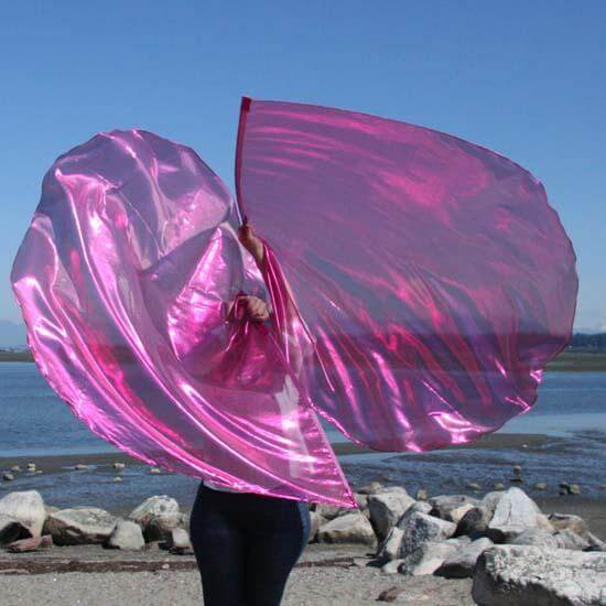 Vibrant scarlet pink worship flags in motion by the water’s edge, reflecting light and symbolizing healing, joy, and extravagant love in prophetic dance.