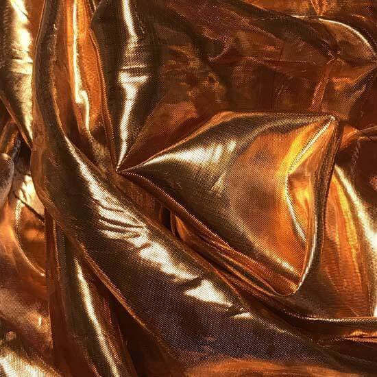 Close-up of metallic copper worship flag fabric with a shimmering texture, used in praise dance and Christian worship movement.