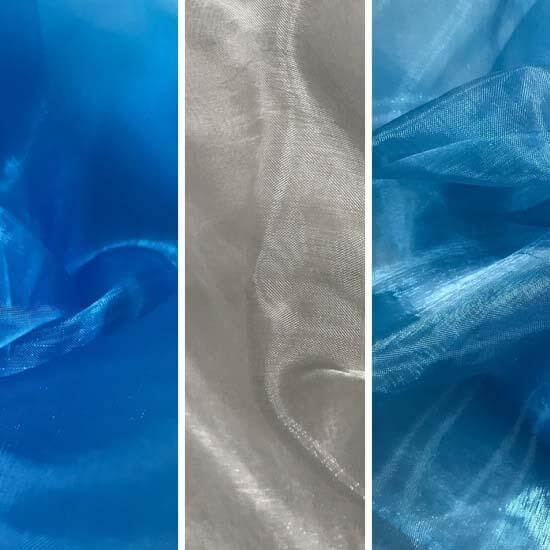 Close-up view of three sheer fabric samples displayed vertically side-by-side: vibrant royal blue on the left, soft white in the center, and icy blue on the right. Each fabric shows subtle shimmer and gentle folds.
