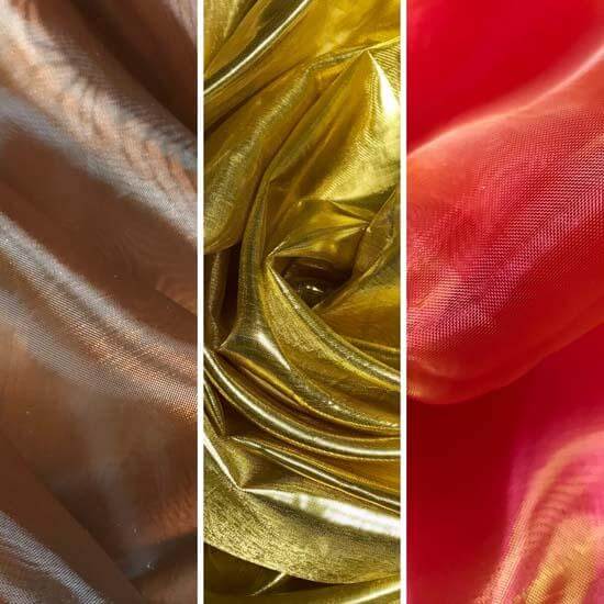 Close-up image of three different shimmer fabrics. From left to right: a bronze sheer fabric with soft waves, a richly reflective metallic gold fabric with tightly gathered folds, and a translucent coral-red fabric with a gentle, flowing texture. The trio showcases a vibrant and luxurious color palette.
