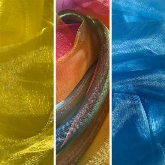 Close-up view of shimmering organza fabric in three colors—yellow on the left, a blend of scarlet and orange in the center, and vibrant blue on the right—arranged in soft folds to highlight texture and light reflection.