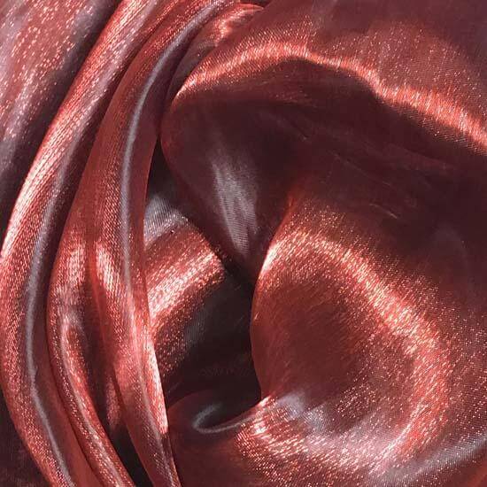 Close-up of shimmery red iridescent fabric, draped in soft folds with reflective highlights, ideal for worship flags or expressive movement in dance.