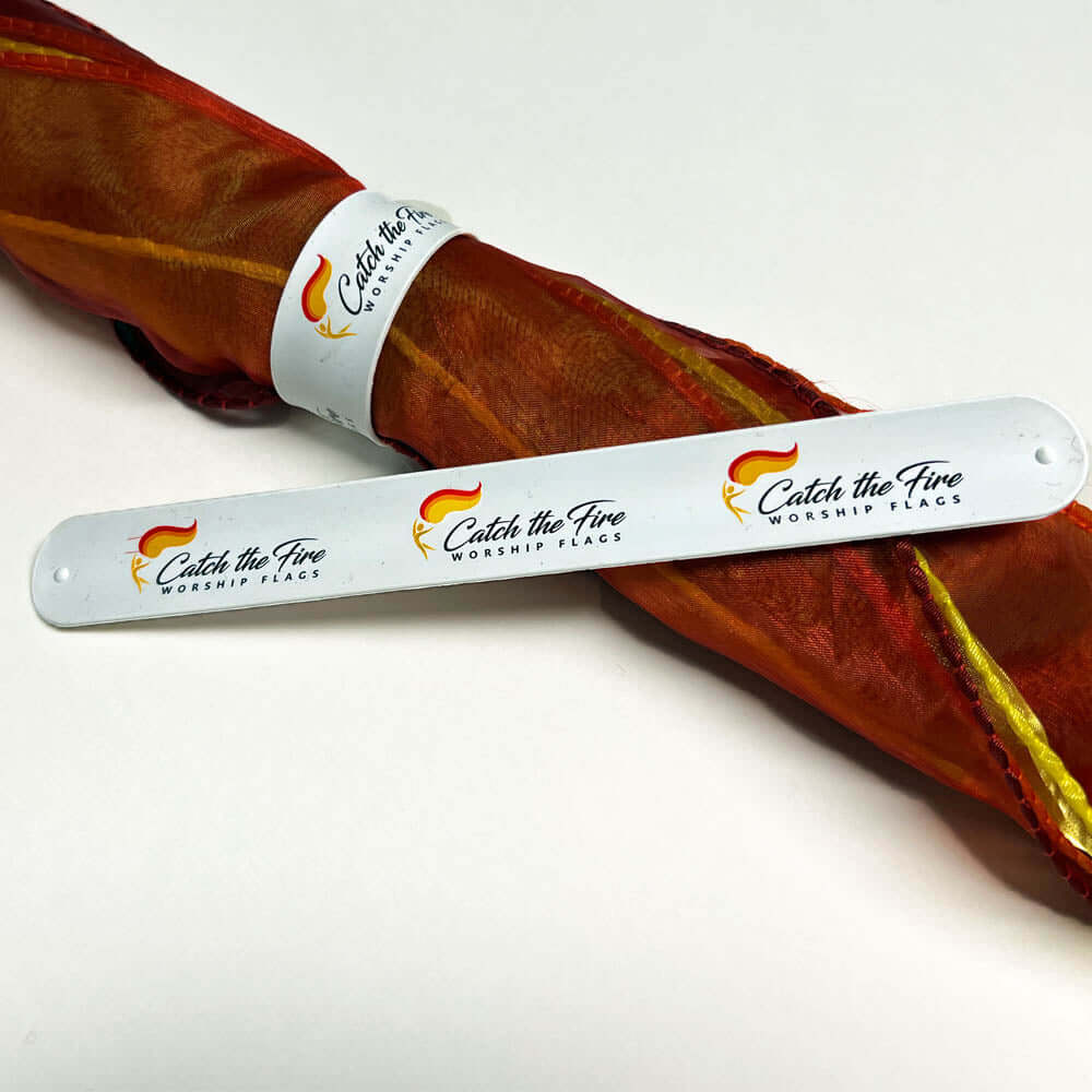 Wrap bracelet with Catch the Fire Worship Flags logo securing a folded worship flag, ideal for storing or gifting.