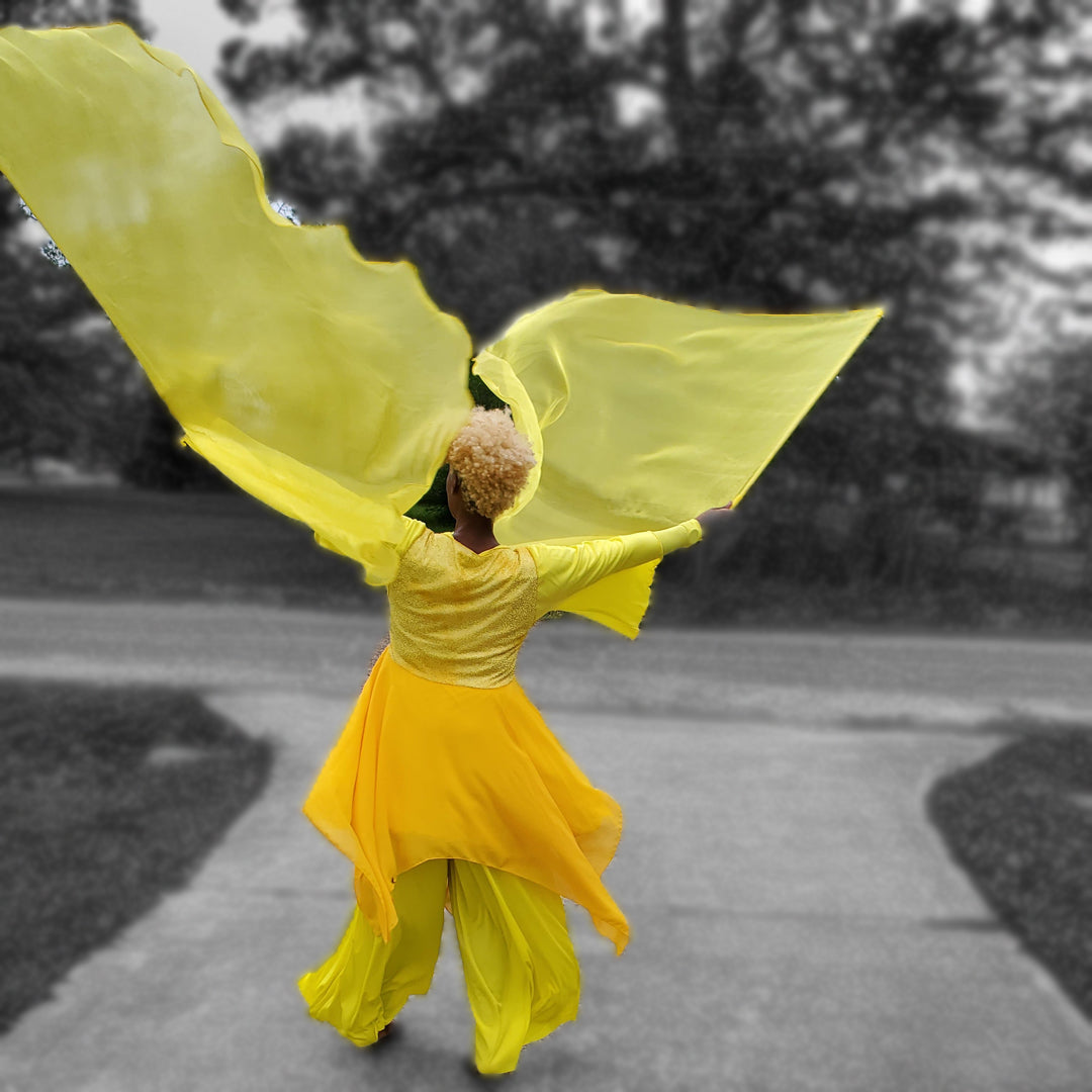 Worshipper waving yellow shimmer flags in prophetic movement, symbolizing hope, discernment, and divine vindication in biblical worship.
