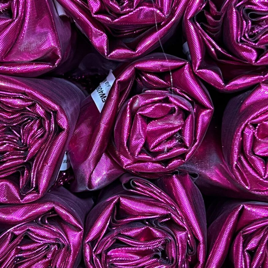 Rolled scarlet pink metallic fabric for DIY worship flags, symbolizing healing, joy, and extravagant love. 