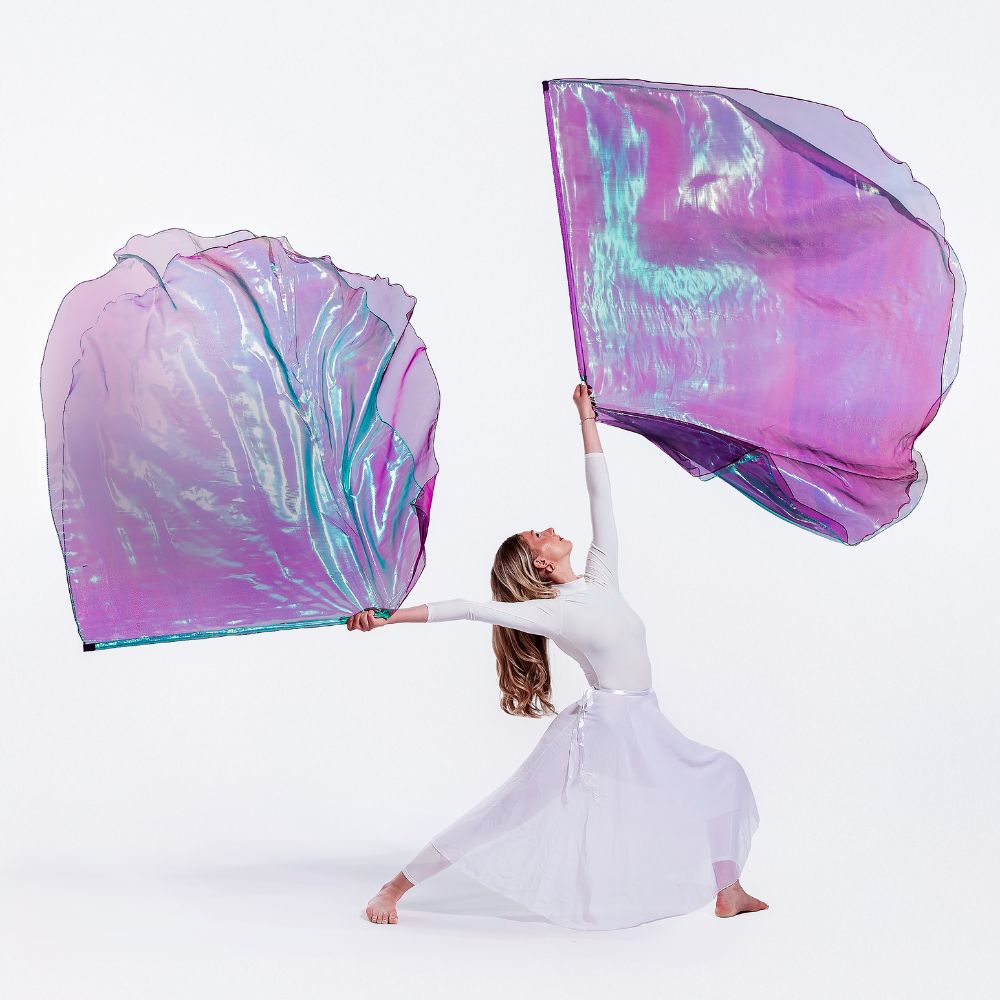 Praise dancer in a white outfit holding Anointed, double-layer large, colorful, iridescent worship wings against a white background