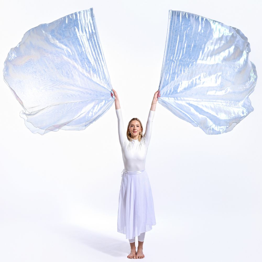 Worship dancer stretches with double-layer Holy & Blameless iridescent flags flowing wide. A radiant expression of praise representing the Holy Spirit and overcoming faith.
