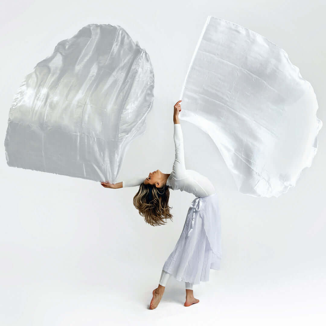Worship dancer lifts two flowing white flags in graceful motion, symbolizing purity, surrender, and the holiness of God.