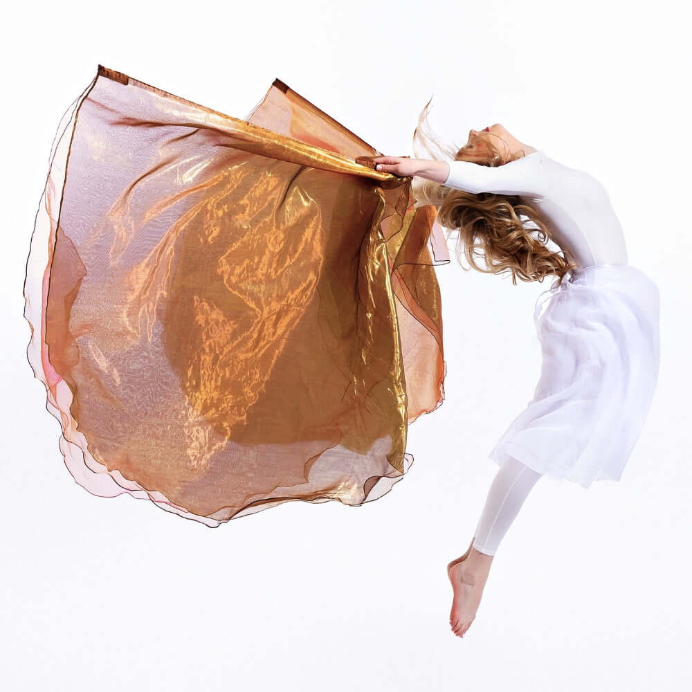 Airborne praise dancer lifts Jehovah Sabaoth worship flags in double leap—bronze shimmer flags symbolizing the Lord mighty in battle, Psalm 24.