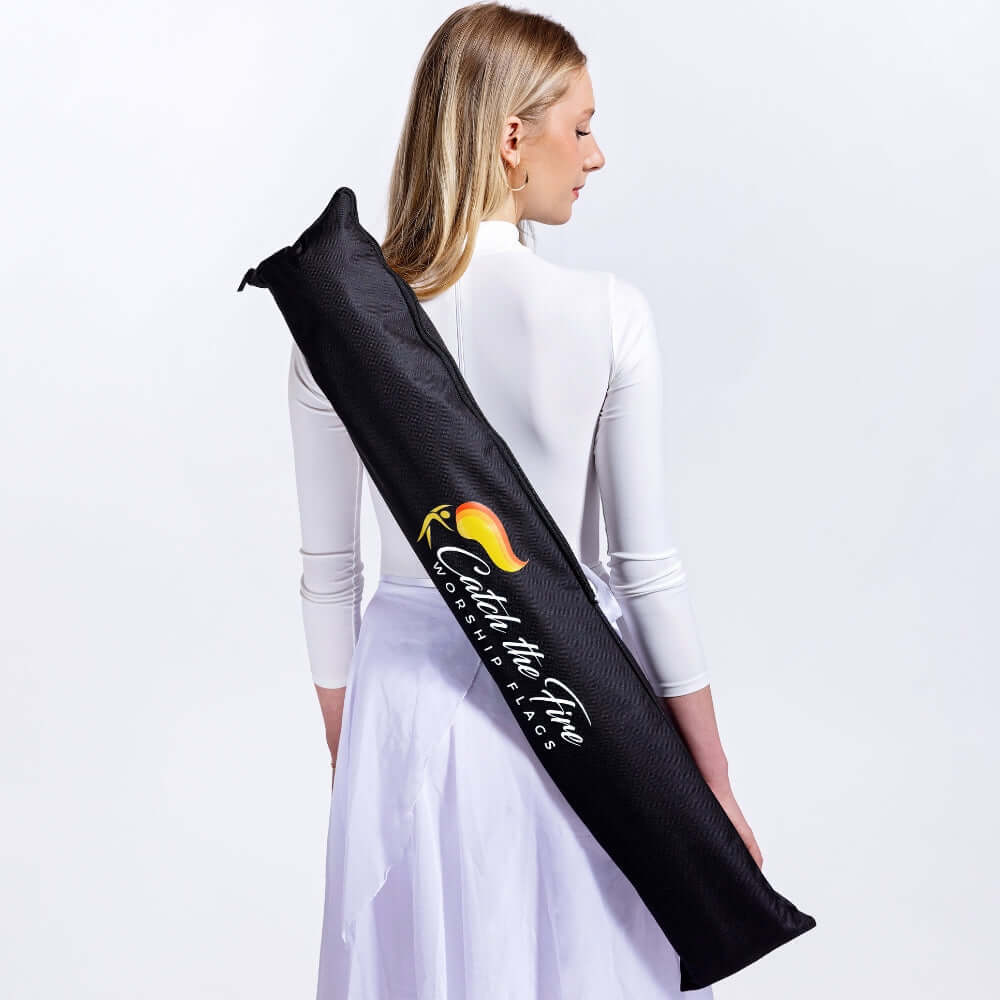 Catch the Fire Worship Flag storage bag worn over shoulder by dancer in white—durable carrying case for worship flags, poles, and accessories. Storage and transport for 1-10 worship flags