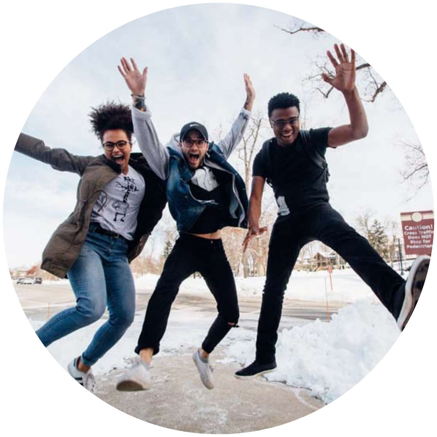 Three young adults jumping joyfully in a snowy urban setting, celebrating community and friendship